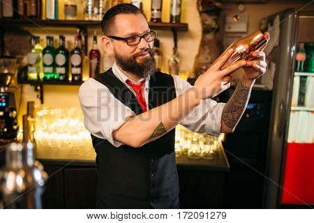 Bartender flair with shaker behind a bar counter