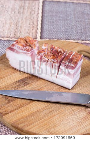Piece Of Bacon With Kitchen Knife On The Wooden Board