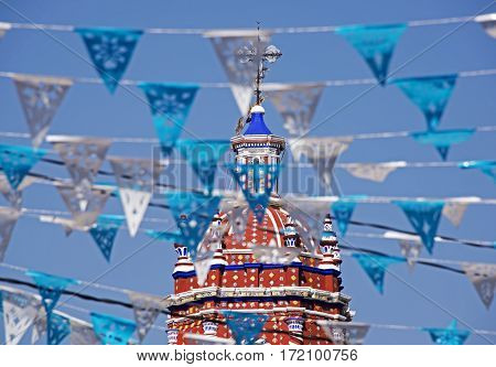 Decorative street banners with church tower in background Cholula Mexico