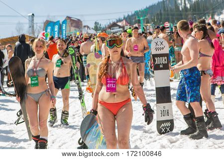 Group Of Young Happy Pretty Women On A Snowboard In Colorful Bikini With Flags.