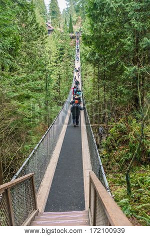 Vancouver Canada - January 28 2017: Many sightseers make their way across the Capilano Suspension Bridge.
