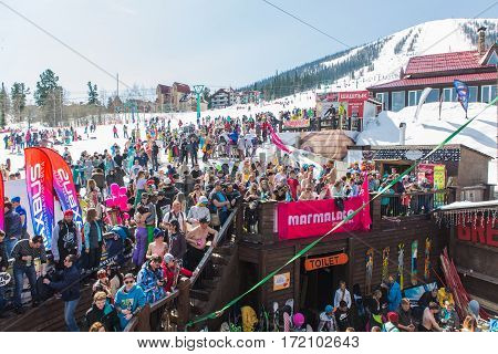 Group Of Young Happy Pretty Women On A Snowboard In Colorful Bikini With Flags.