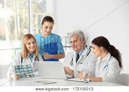 Team of doctors exploring roentgenogram at table