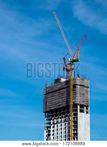 Industrial construction crane for high rise building with blue sky background