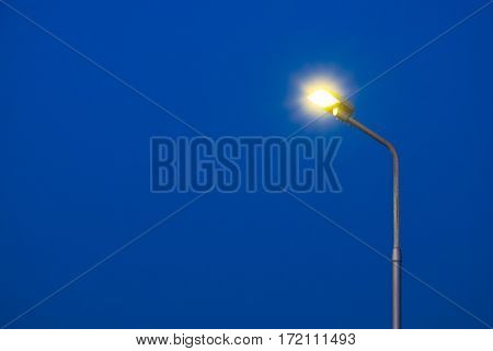 A part of top street light pole with dark blue sky background in twilight time.