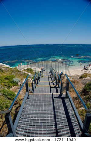 A stair on an island linked to the sandy white beach and crystal blue sea