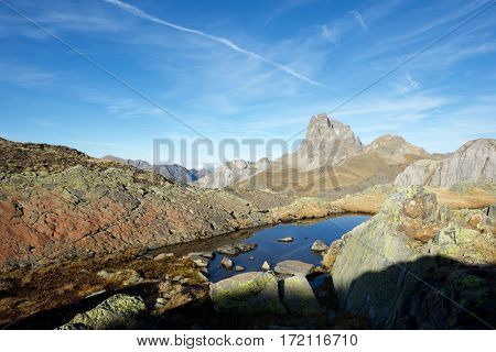 Midi Dossau Peak reflected in a lake. Ossau Valley, Pyrenees National Park, Pyrenees, France.