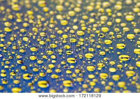 Abstract blue-yellow background with gradient color water drops on glass with reflection, bockeh, macro