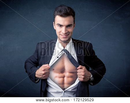 Businessman tearing off his shirt and showing mucular body concept on background