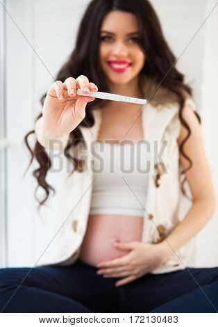 Happy Smiling Woman Holding And Showing Positive Home Pregnancy Test. Pregnancy, Fertility, Maternit