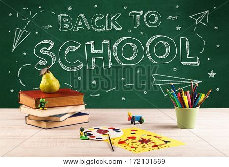 Back to school concepty with writing on blackboard and desk, apple, books, items