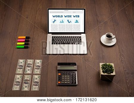Laptop computer on wooden desk with office suplies