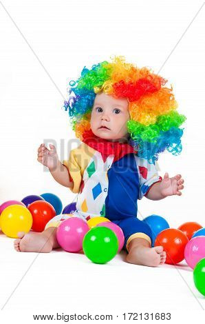 Children clown with a red nose multicolored wig in with balls. On a white background.