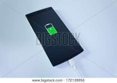 Mobile smart phone is charging with graphic on it screen