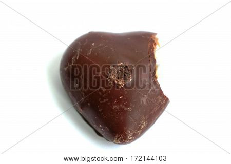 Chocolate gingerbread heart with a bite mark on a white background