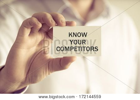 Businessman Holding Know Your Competitors Message Card