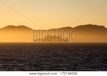 Beautiful view of famous Alcatraz Island illuminated in majestic golden evening light at sunset in summer San Francisco Bay, California, USA
