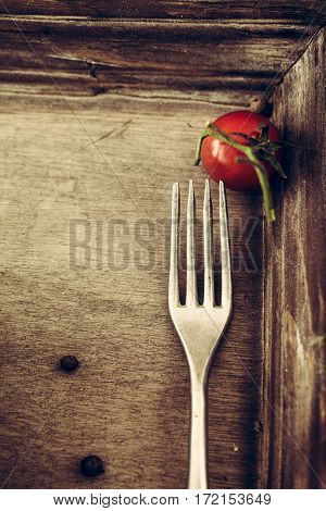 Food background. wood with fork and tomao