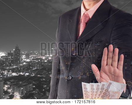 Double exposure of businessman decline a bribe with cityscape night light background. Stop corruption and fraud concepts