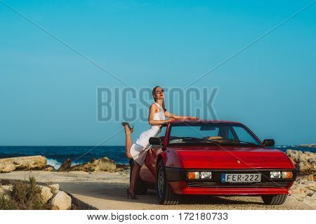 Young Beautiful Girl In Sunglasses Posing Near The Red Ferrari