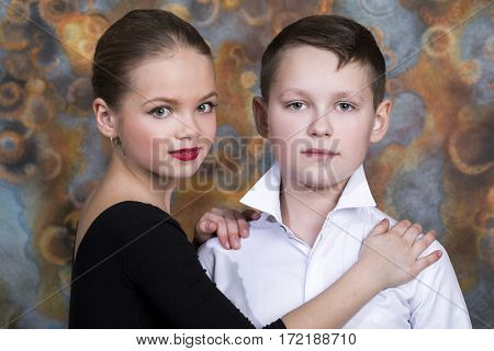 Young boy and girl are dancing on the studio wall background
