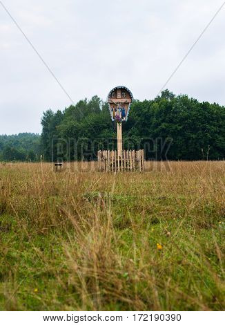 Old traditional wooden crucifix in the field in the Carpathian region in Ukraine.