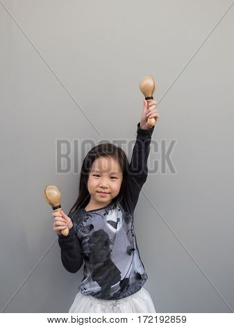 Little Asian Child Play The Maracas, Gray Background