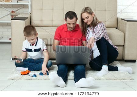 Family having fun chating on internet with laptop. Family having fun chating on internet with laptop. Three people communicate on Skype at home in living room.