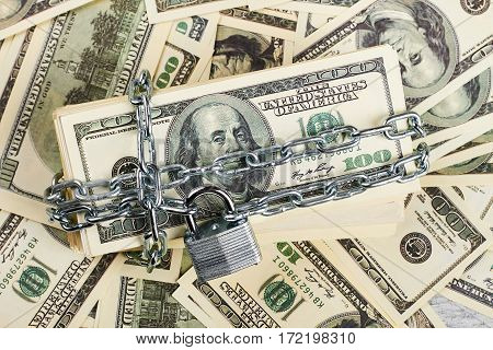American dollars wrapped in chain. Financial security and stability.