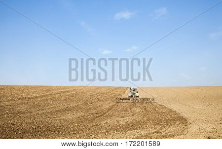 Harrowing the soil with tine harrows in spring in Ukraine.