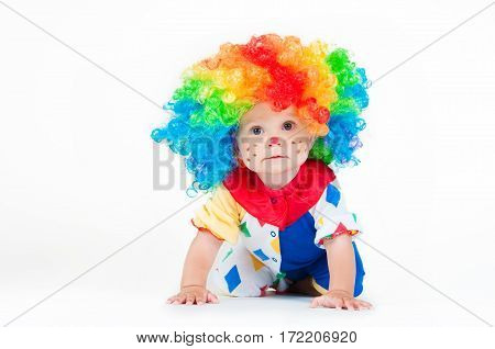 Children clown with a red nose multicolored wig in with balls. On a white background.