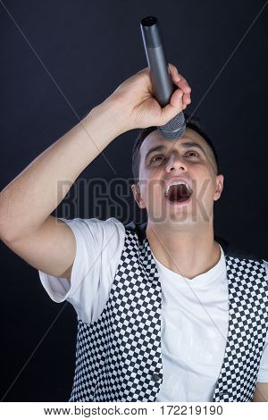 Young Male Black-haired Vocalist Performs Singing To Microphone