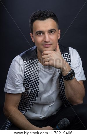 Young Male Black-haired Singer Poses Singing To Microphone
