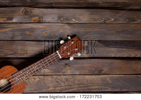 Musical string instrument ukulele on wooden background