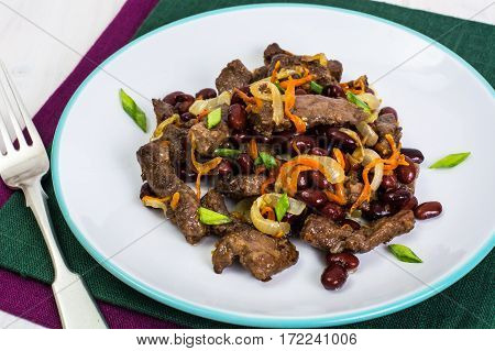 Beef liver, onions, carrots fried on palte. Studio Photo