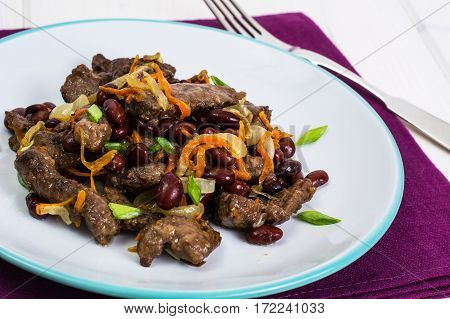 Beef liver, onions, carrots fried on palte. Studio Photo