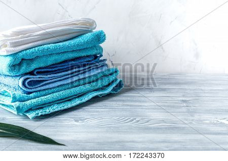 blue towels pile in housekeeping set on laudry gray background mock-up