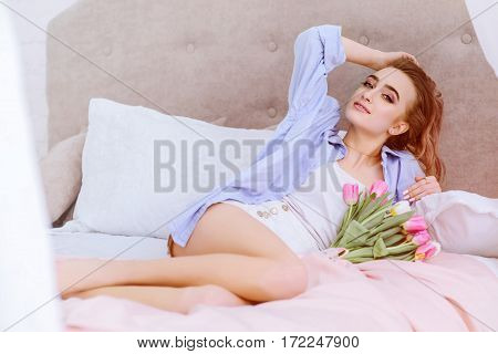 attractive female resting on the bed in the light bedroom