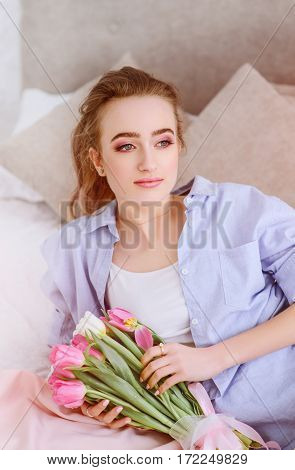 attractive female resting on the bed in the light bedroom