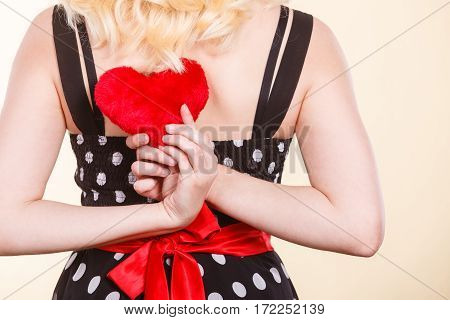 Valentine day gift proof of love romantic present concept. Woman in retro polka dot dress holding small furry red heart