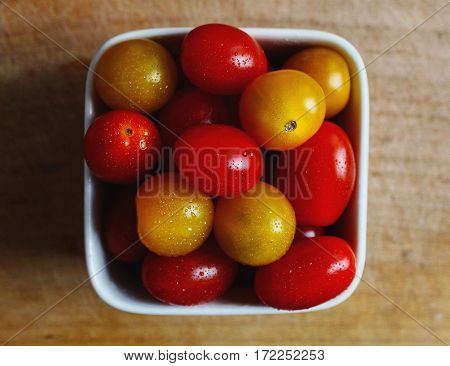Red and yellow cherry tomatoes in a vessel