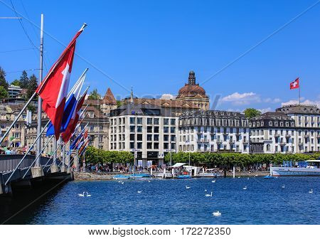 Lucerne, Switzerland - 8 May, 2016: people and flags on the Seebrucke bridge, buildings along Lake Lucerne. Lucerne is a city in central Switzerland, it is the capital of the Swiss Canton of Lucerne and the capital of the district of the same name.