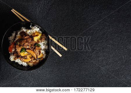 Asian rice with beef meat and vegetagles on dark background copy space