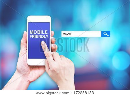 Hand Touch Mobile Phone With  Mobile Friendly Word With Search Box At Blurred Blue Background, Digit