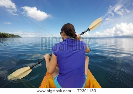 Young woman in a kayak kayaking in a tropical resort on Vanua Levu Island Fiji. Real people copy space