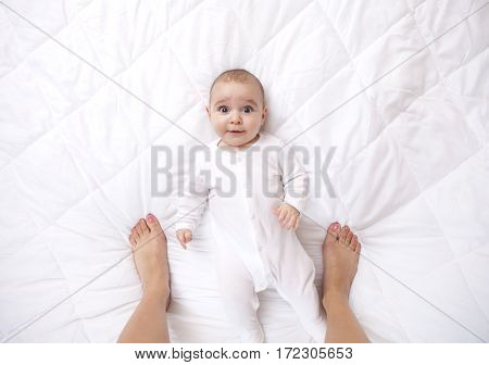Happy Addorable Baby Boy And The Legs Of His Mother.