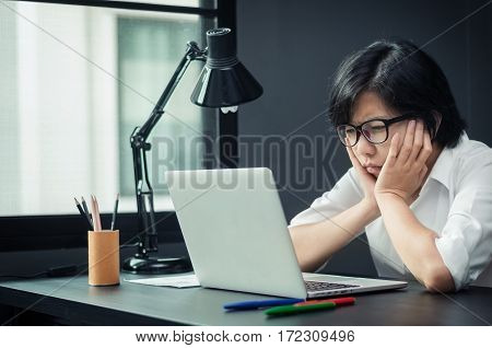 Close up of asian girl thinking about her work. Portrait of stressed young business woman in office. Exhausted and tired of business woman.