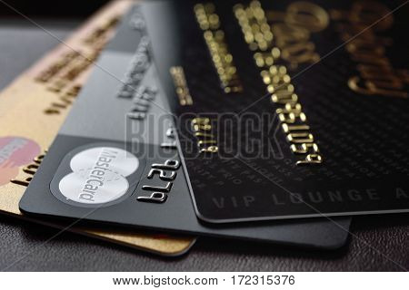 RUSSIA MOSCOW - FEB 22 2015: Premium credit card MasterCard Black Edition Gold Edition and Priority Pass access on the black leather background. Small depth of field