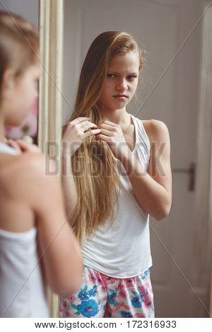 Teenage girl checking her face and body in the mirror