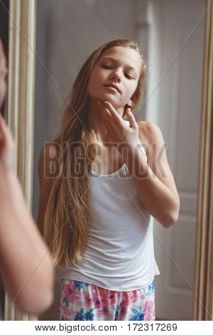 Teenage girl checking her face and body in the mirror